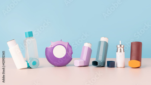 Set of asthma inhalers for asthma and COPD patients on table. Pharmaceutical product is used to treat lung inflammation and prevent asthma attack symptoms. Health care and medical concept. Copy space. photo