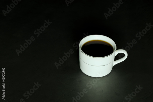 black coffee in a white cup on a black background