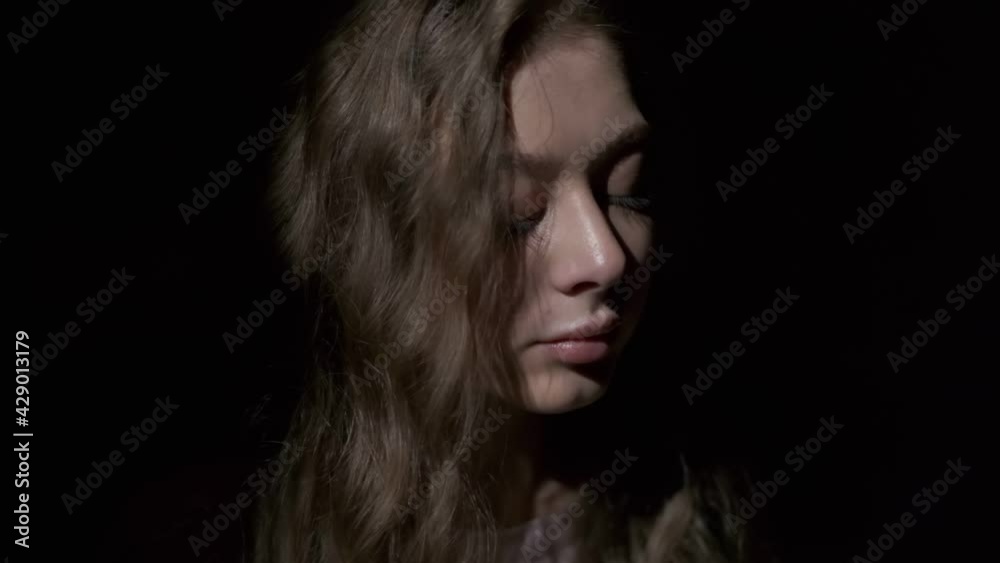 Close-up of girl with long light brown hair and grey eyes drinking coffee with pleasure from a white cup. Filmed in full face on a black background Close-up of girl with long light brown hair and grey eyes drinking coffee with pleasure from a white cup. Filmed in full face on a black background