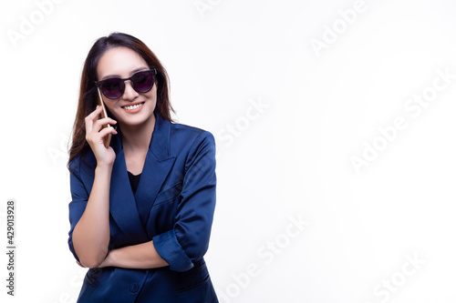 Happy Beautiful business woman using smart phone stand over isolated on white background copy space Young business girl wear sunglasses Fashion of blue suit Modern business and working woman concept