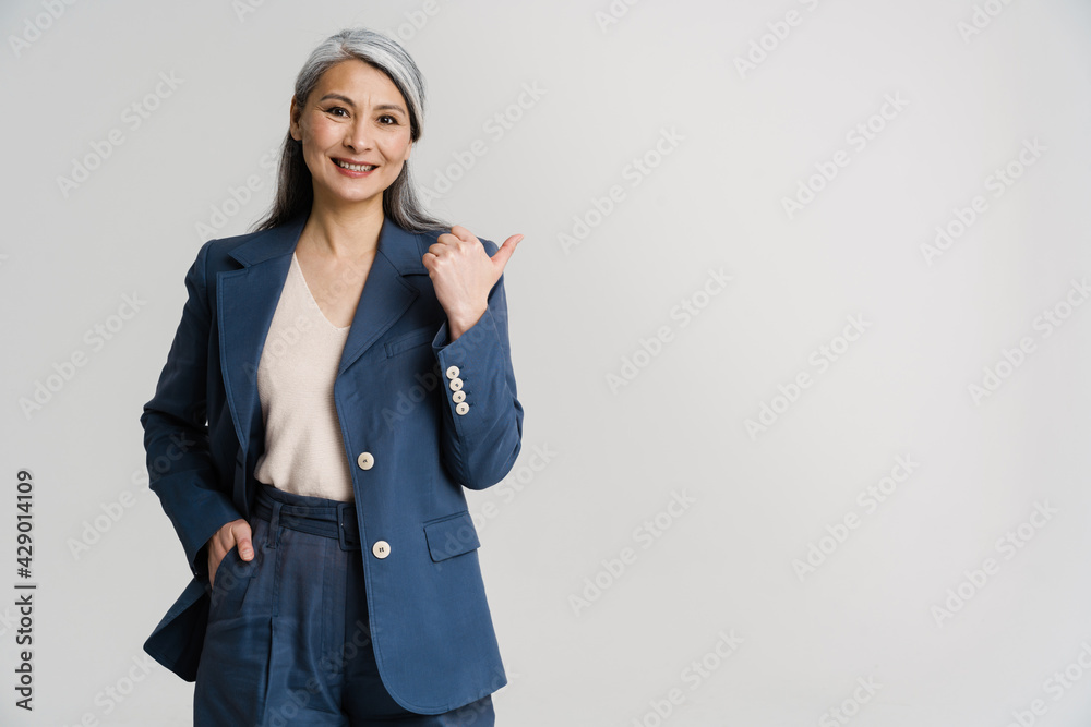 Asian mature woman smiling while pointing finger aside Asian mature woman smiling while pointing finger aside