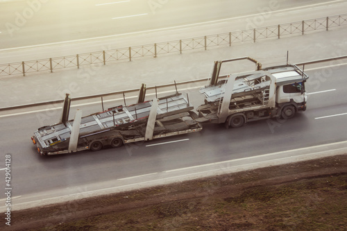 Truck with empty double-deck trailer for transporting new cars. photo