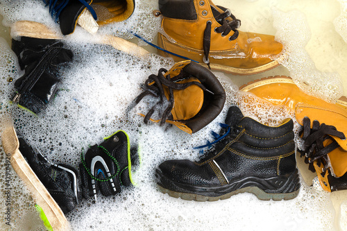 many different dirty shoes are in the bathroom filled with water