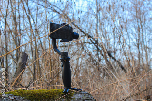 Steadicam with a phone stands in the woods