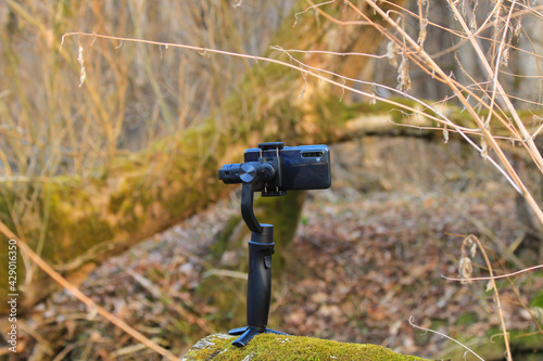Steadicam with a phone stands in the woods