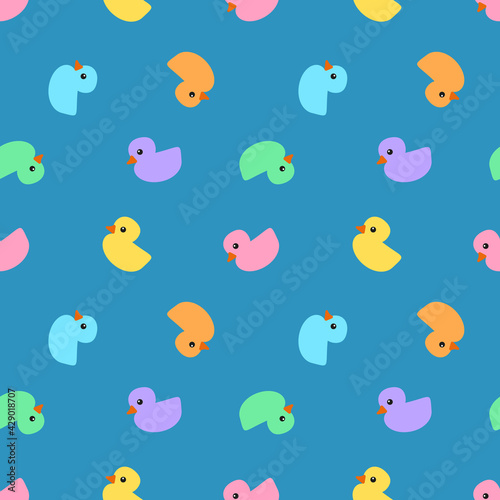 Little ducks in pastel colours, including yellow, orange, pink, violet, blue and mint, with orange beaks and black eyes on blue background, seamless pattern 