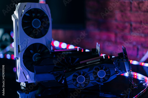 фотографія Graphics cards of different sizes and configurations on black table under neon light
