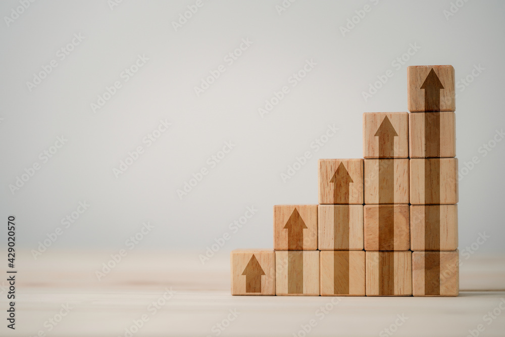 Step of increasing arrow print screen on wooden cube block with copy space on table , Business profit and sale growth concept. Step of increasing arrow print screen on wooden cube block with copy space on table , Business profit and sale growth concept.