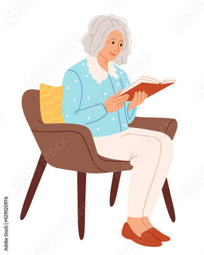 Stylish old woman reads in a chair.Comfortable chair for reading. Stay at home and have a good time.