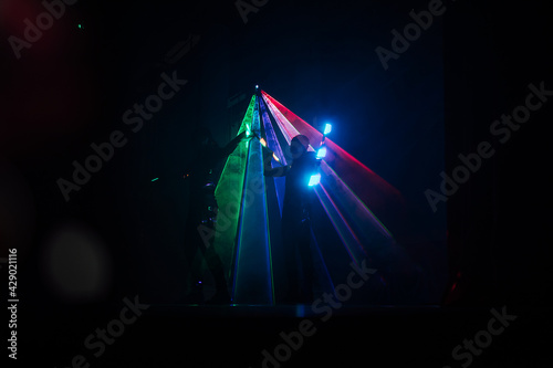 digital art dance show in LED costumes. neon fans in the hands of artists dancing in the dark on stage