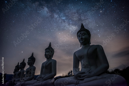 Milky way galaxy over many of buddha statues at Phu Phra Ban Mak Khaeng, Dan Sai, Loei, Thailand. photo