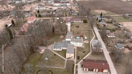 Drone flight over small rural vilage Umurga during spring time, Latvia