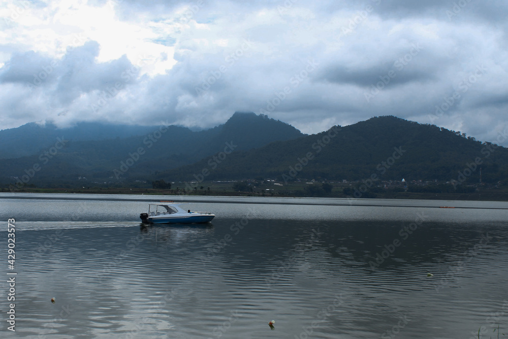 Boat runs against the backdrop of the mountains