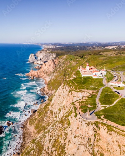 Aerial view of Cabo da Roca lighthouse with majestic coastline looking the Atlantic Ocean, a famous landmark in Colares, Lisbon, Portugal.