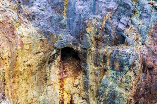 Colorful rock wall with a mining shaft