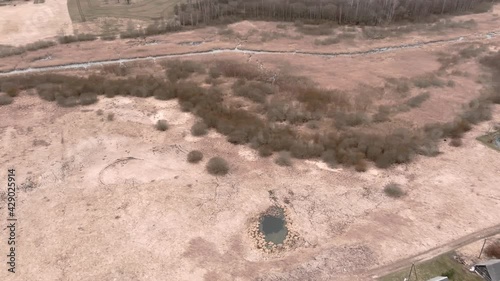 Drone flight over small rural vilage Umurga during spring time, Latvia