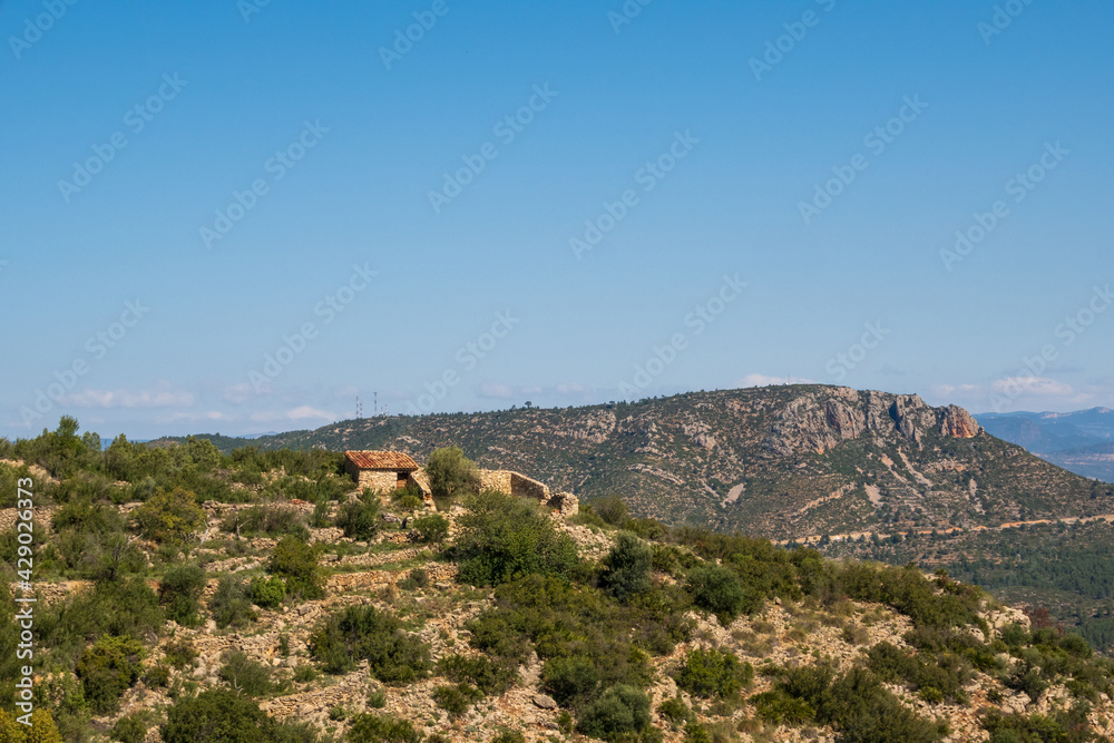 Panoramic of a mountainous landscape, with a stone shelter built on the top of the hill Panoramic of a mountainous landscape, with a stone shelter built on the top of the hill