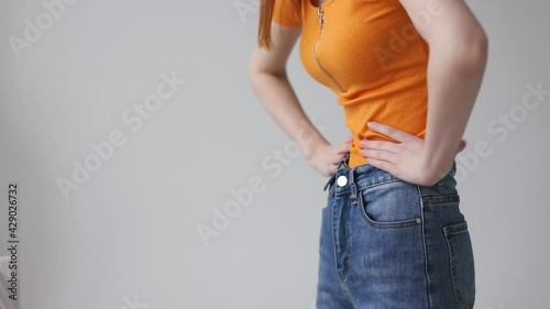 A woman looks in the mirror and evaluates her figure, weight loss and excess weight