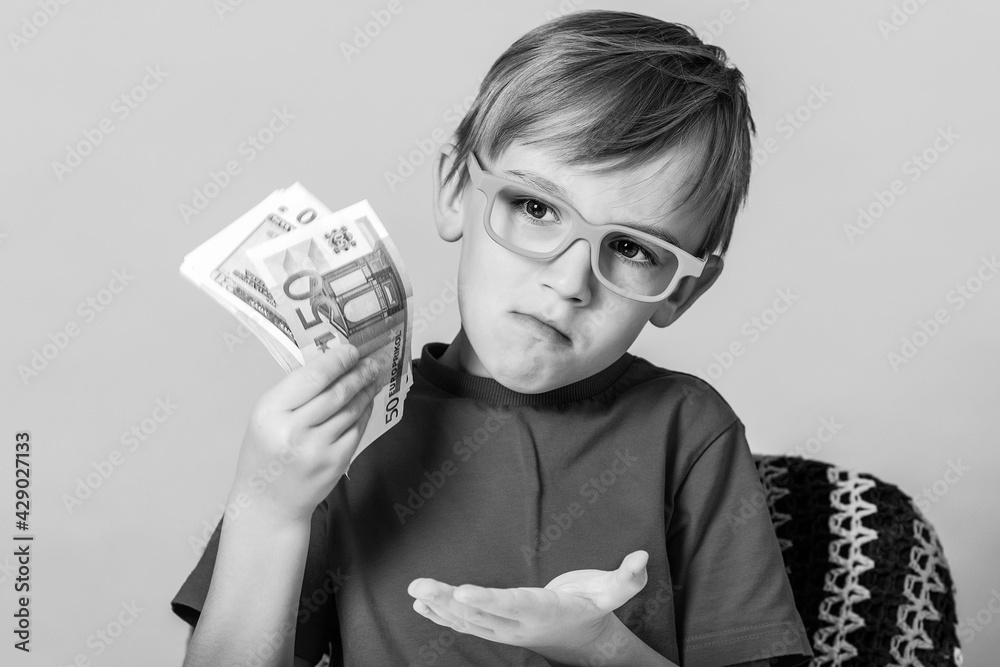 Clever boy holding fan of money. Financial literacy of children. Winner