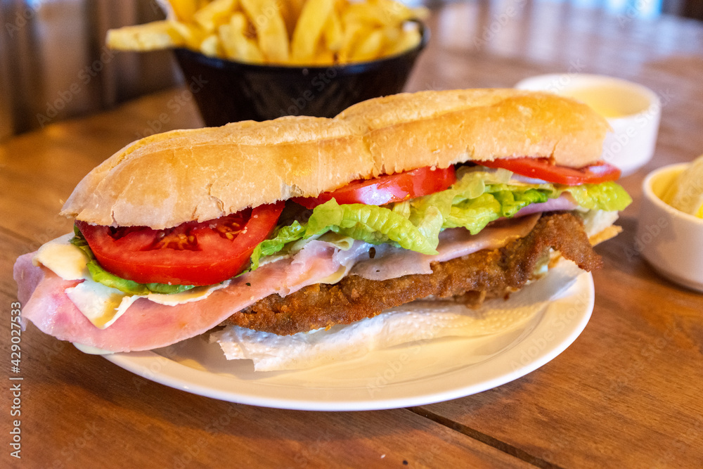 Foto de sandwich de milanesa con papas fritas do Stock | Adobe Stock