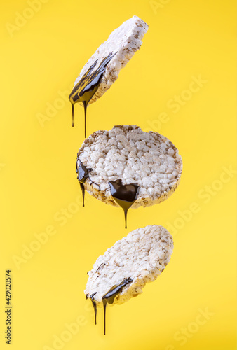 multi-grain cracker with liquid chocolate falls on a yellow background