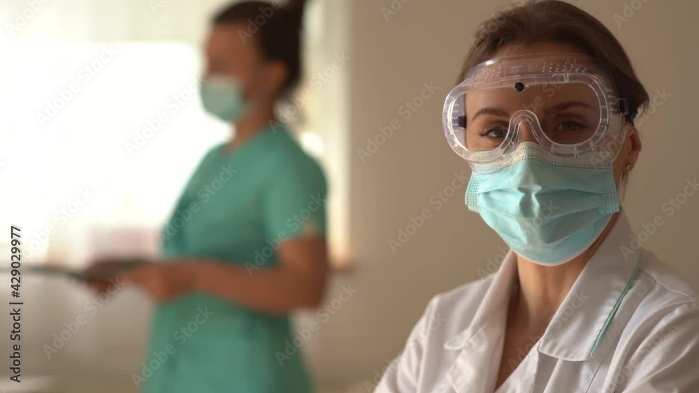 Portrait of a tired female therapist wearing protective shield and mask. Doctor after work, close portrait Portrait of a tired female therapist wearing protective shield and mask. Doctor after work, close portrait