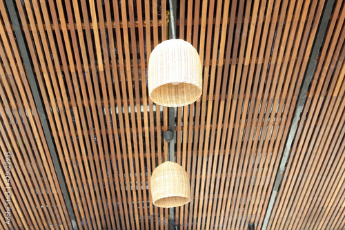 Rattan lamp hanging on the slatted ceiling.