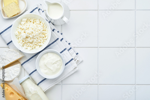 Glass of milk, cottage cheese, ricotta, sour cream, cheese, camembert and butter on white table background. Different dairy products. Milk concept. Top view with copy space. Mock up.