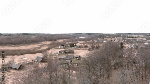 Drone flight over small rural vilage Umurga during spring time, Latvia