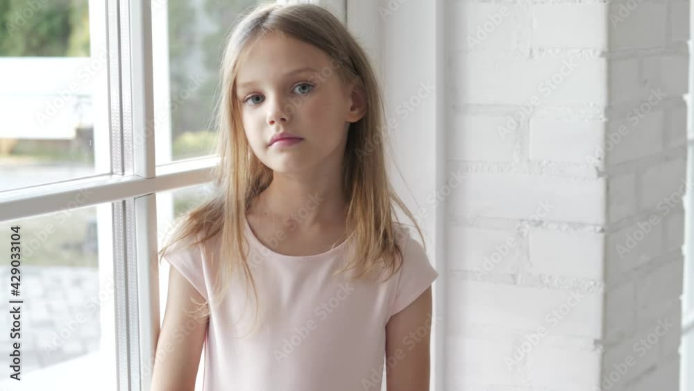 Fashionable Cute kid child girl model portrait. Little child smiling and looking at camera near window. People, beauty, children, kids lifestyle concept Fashionable Cute kid child girl model portrait. Little child smiling and looking at camera near window. People, beauty, children, kids lifestyle concept