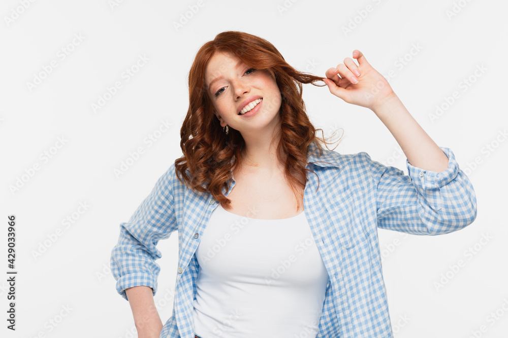 happy young woman in blue checkered shirt adjusting curly red hair isolated on white. happy young woman in blue checkered shirt adjusting curly red hair isolated on white.