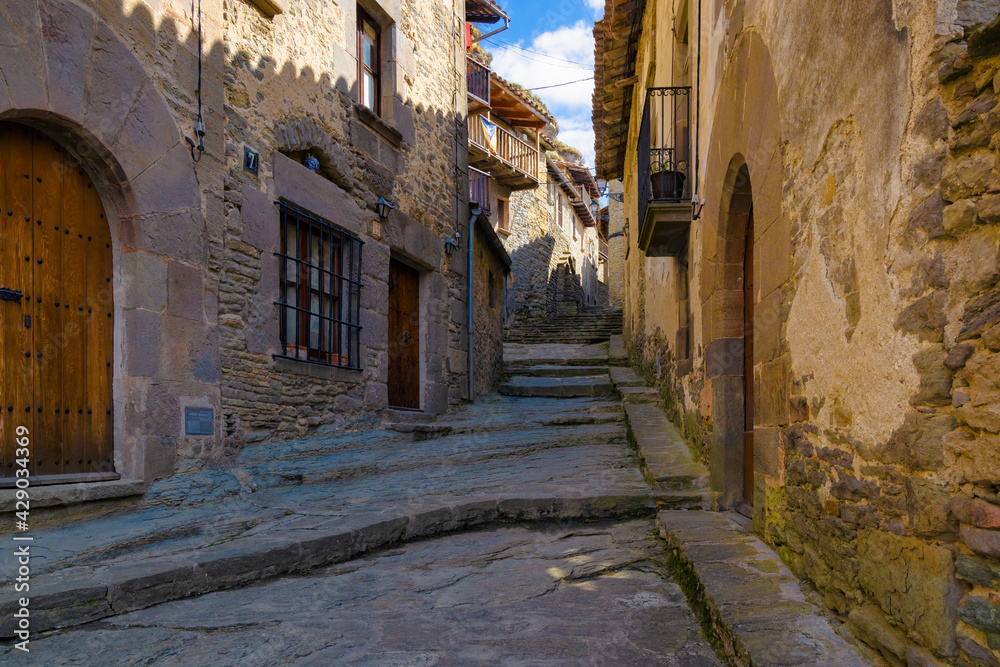 View of Fossar street, one of the most typical streets of the medieval center of Rupit where all the houses have the aesthetics of the medieval centuries. Catalonia, Spain