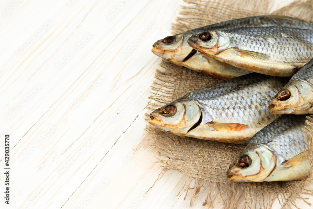 dry fish on a white wooden background with room for text. dry fish on a white wooden background with room for text.