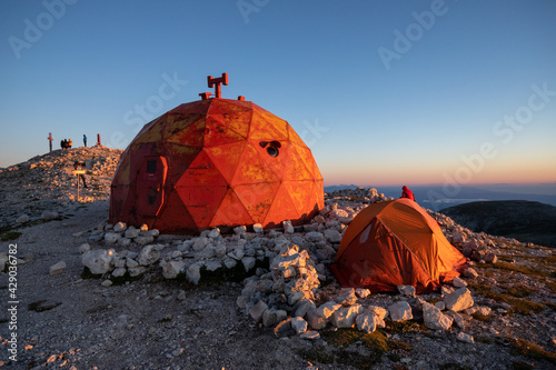 Pelino bivouac and tent on the top of Monte Amaro at sunrise. Trekking in the Majella national park, the second highest peak of the Apennines. Maiella mountain massif, Abruzzo, L'Aquila