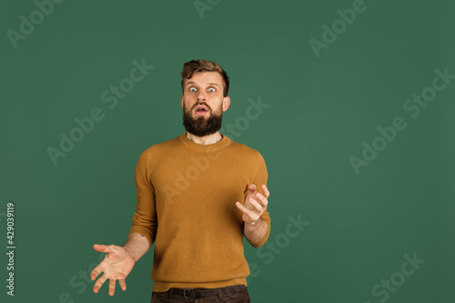 Caucasian man's portrait isolated over green studio background with copyspace