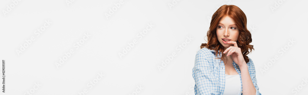 pensive redhead young woman in blue checkered shirt looking away isolated on white, banner. pensive redhead young woman in blue checkered shirt looking away isolated on white, banner.