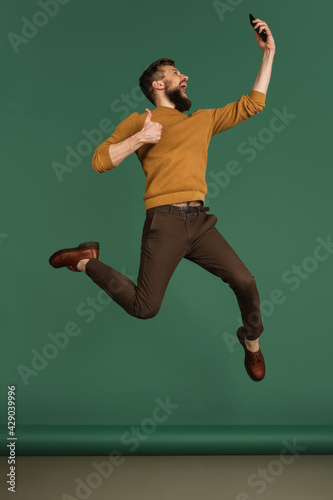Caucasian man's portrait isolated over green studio background with copyspace