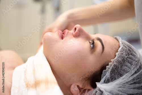 Side view closeup portrait of beautiful young woman lying on spa bed prepared for facial treatment and massage in luxury spa resort. Wellness, stress relief and rejuvenation concept.