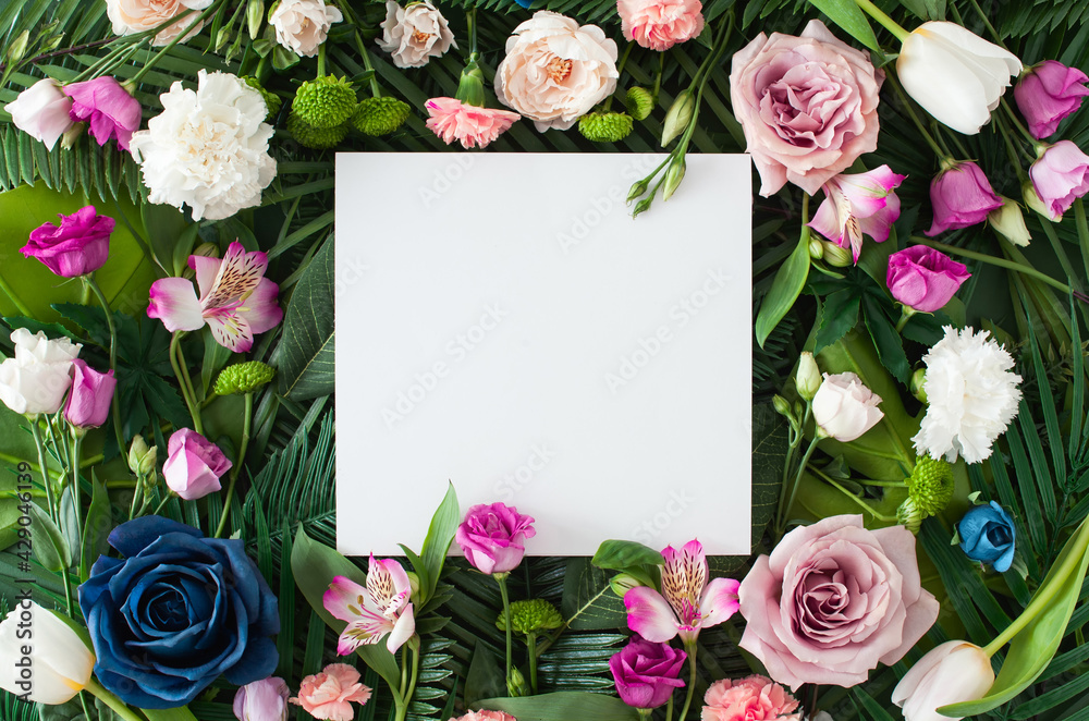 Fototapeta Creative layout made with colorful flowers and green leaves with paper card note. 