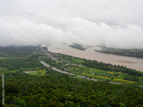 The Top view of the Mekong River, clouds, and houses of Thailand on the other side are in Laos.