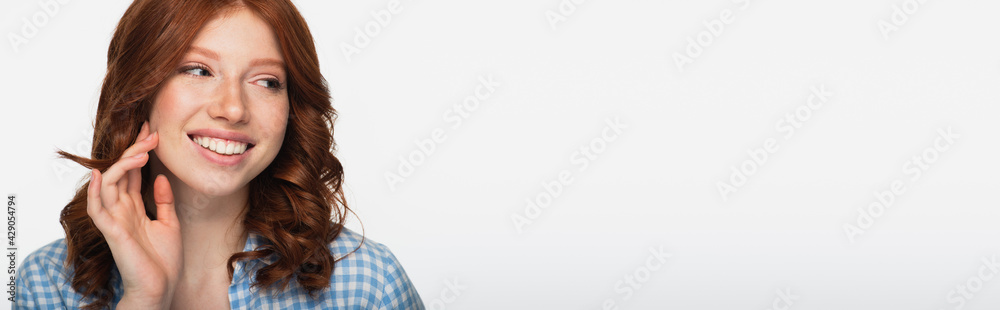 cheerful redhead woman in blue plaid shirt looking away isolated on white, banner. cheerful redhead woman in blue plaid shirt looking away isolated on white, banner.