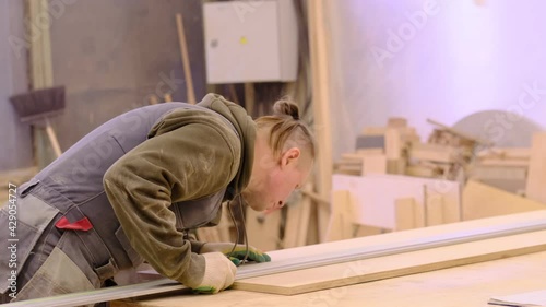 Close up. Carpenter at workshop polishes wooden board with a electric orbital sander. Woodwork and furniture making concept. photo