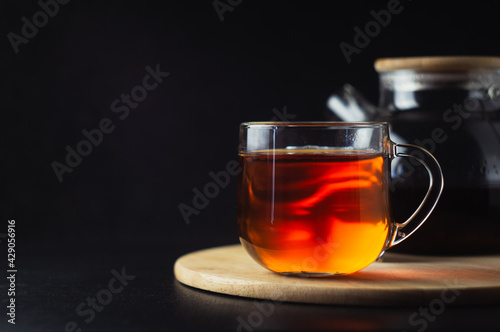 A mug of black tea stands on a wooden stand