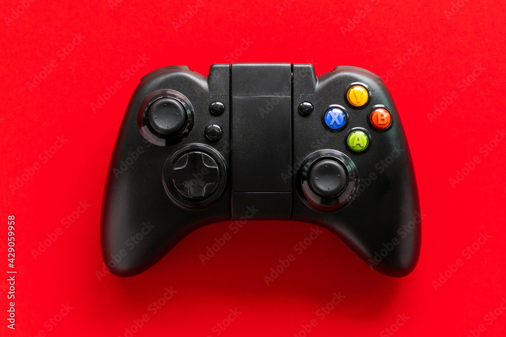 A Black game Joystick isolated on a red background A Black game Joystick isolated on a red background