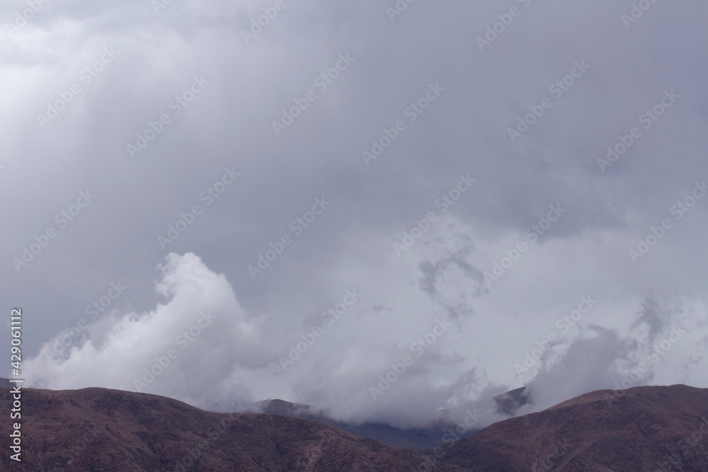 The Andes mountains early in the morning. View of the brown mountains, and mountain peak under a cloudy sky. 