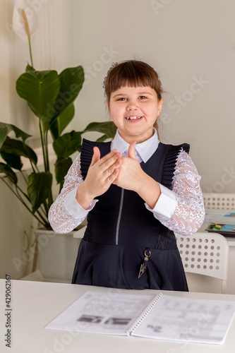 A girl pupul  sits at  a desk in the classroom and reads a book. Back to school concept photo