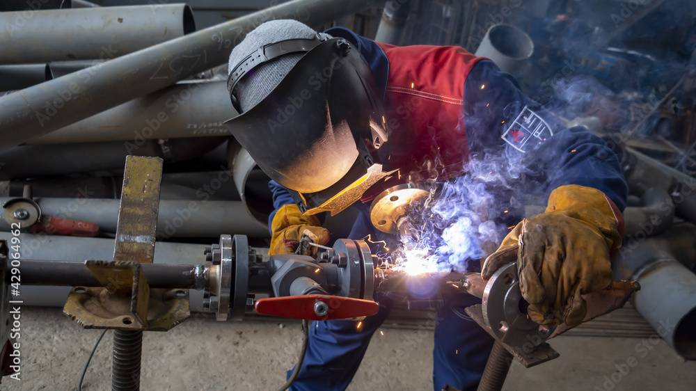 professional welder cooks pipe DN30 by manual arc welding professional welder cooks pipe DN30 by manual arc welding