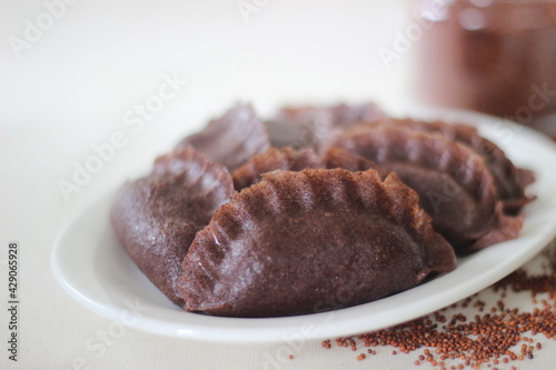 Steamed dumplings made from finger millet flour. It is stuffed with coconut and jaggery to make it sweeter. photo