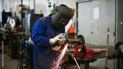 Worker operating an angle grinder and making lots of sparks