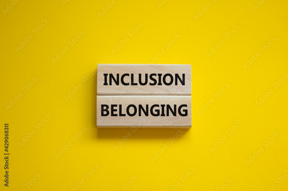 Belonging and inclusion symbol. Wooden blocks with words 'Belonging, inclusion' on beautiful yellow background. Business, belonging and inclusion concept. Copy space. Belonging and inclusion symbol. Wooden blocks with words 'Belonging, inclusion' on beautiful yellow background. Business, belonging and inclusion concept. Copy space.